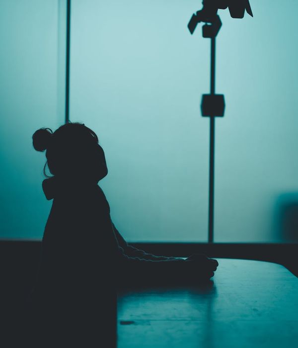 Woman in a calm yoga pose against a light blue background.